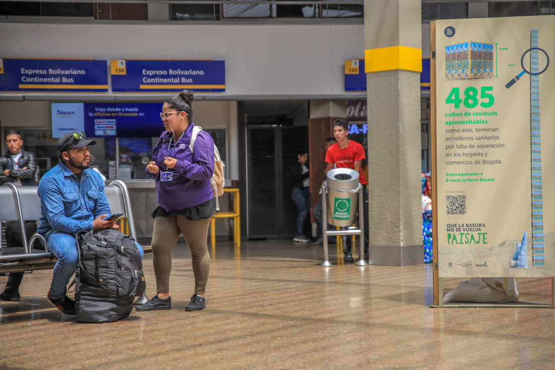 Mujer del observatorio hablando con un hombre en el terminal de transportes.