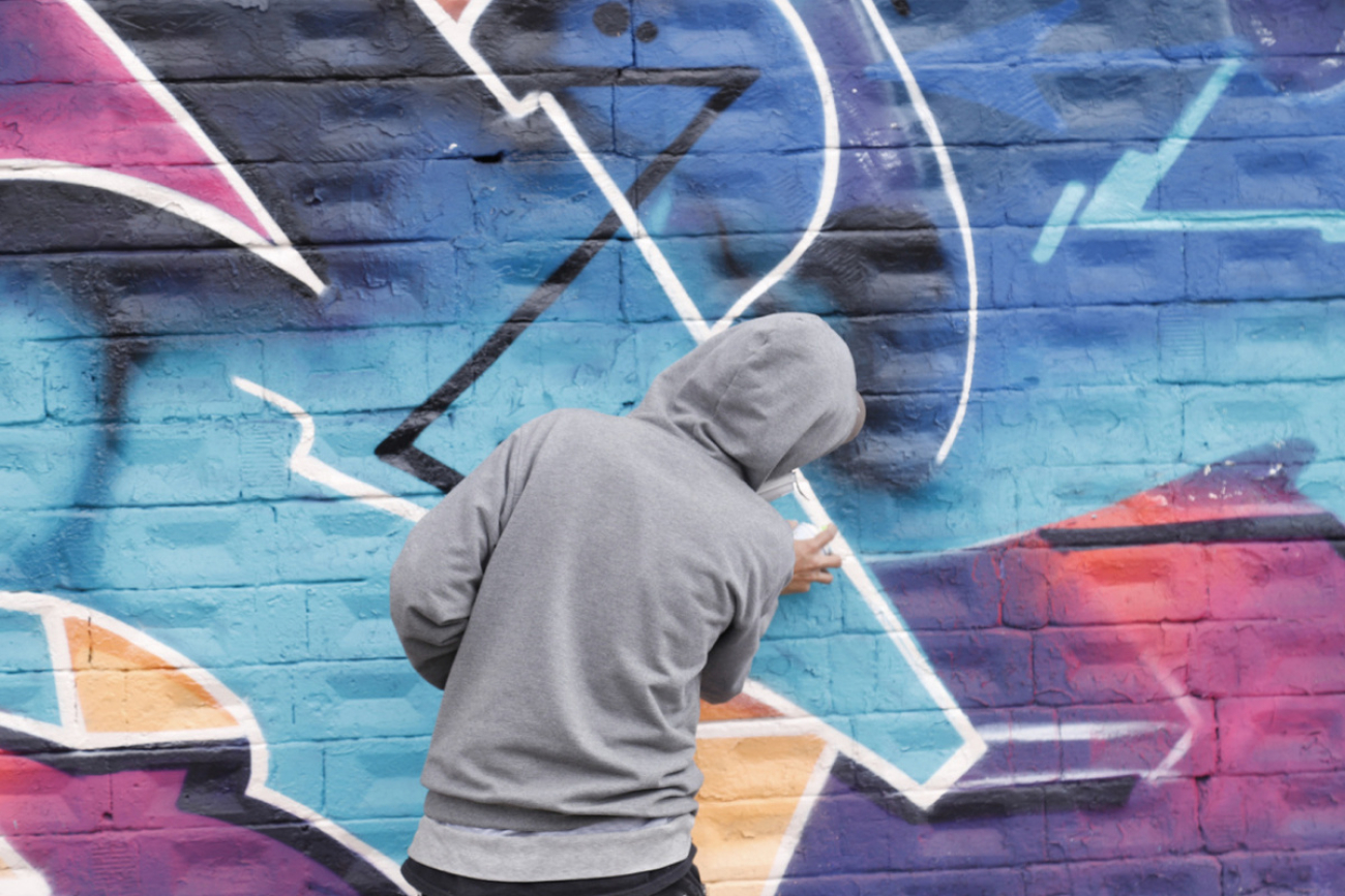 Joven grafitero pintando un mural